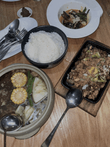 a bowl of rice sits next to a plate of food