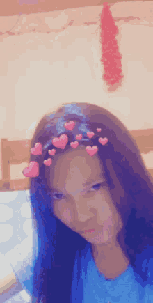 a girl wearing a blue shirt with hearts on her hair