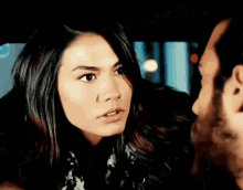 a man and a woman are looking at each other and the woman is looking at the man 's face .