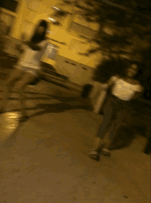 a blurry photo of two women standing on a sidewalk