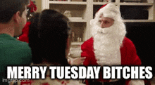 a man dressed as santa claus says merry tuesday bitches while sitting next to a woman .