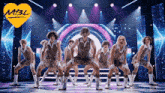 a group of men are dancing on a stage with a yellow heart with m3l written on it