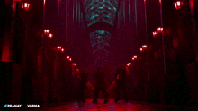 a group of people are dancing in a dark hallway with the name pranay varma on the bottom right