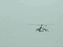 a helicopter is flying in the sky with a person on the back .