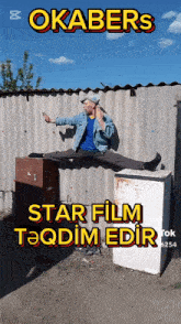 a man is doing splits in front of a sign that says okabers star film taqqdim edir