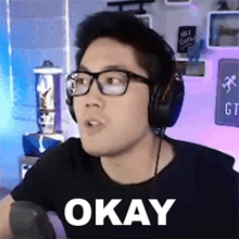 a man wearing glasses and headphones has the word okay written on his face