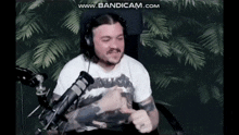a man is sitting in front of a microphone wearing headphones and a shirt that says metallica