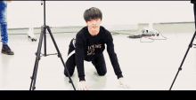a man wearing a loewe shirt is kneeling down