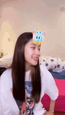 a woman with a stuffed elephant on her head is smiling