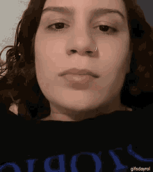 a woman with a nose ring is wearing a black shirt that says ' oioy ' on it