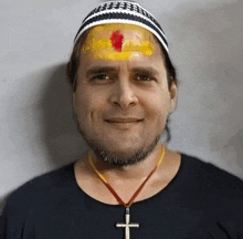 a man wearing a hat and a cross necklace