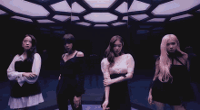 a group of four women standing next to each other in a room