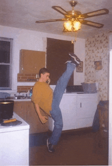 a young man is doing a split in a kitchen