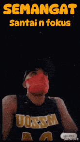 a man wearing a red mask and a uosum jersey