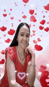 a woman in a red shirt is smiling with hearts flying around her