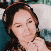 a close up of a woman wearing headphones and a ring on her finger