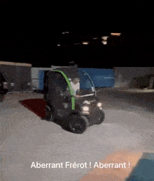 a man is driving a green and black vehicle with the words aberrant frerot written below him