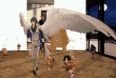 a man with angel wings is standing next to a group of people