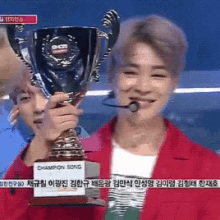 a man is holding a trophy that says champion song on it
