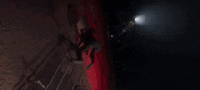 a woman is climbing up a staircase with a light shining on her
