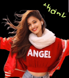 a woman wearing a red sweater that says angel is smiling