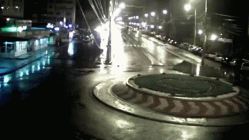 a roundabout in the middle of a street with a red and white striped border