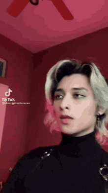 a woman 's face is shown in a tik tok video with a red background