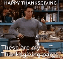 a man from friends is standing in a kitchen with his hands on his hips and giving a thumbs up .