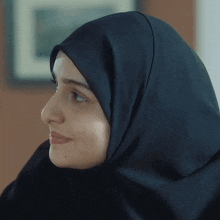 a woman wearing a black hijab is smiling