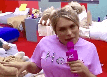 a woman in a purple shirt is holding a purple microphone with the word dal on it .