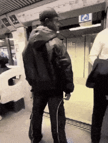 a man in a black jacket is standing in front of a sign that says handicapped