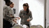 a woman wearing a fra shirt is standing in a room