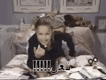 a young girl is sitting on a bed with a bunch of stuffed animals in the background .