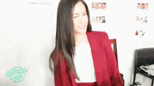 a woman in a red jacket is standing in front of a make up room