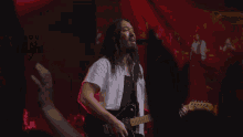a man in a cowboy hat is playing a guitar on stage