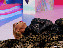 a woman is laying on a leopard print blanket