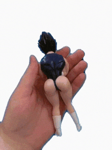 a hand is holding a small figurine of a girl in a blue swimsuit