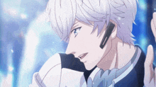 a man with white hair and blue eyes is wearing headphones