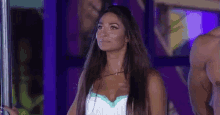 a woman is standing on a pole in front of a man in a purple room .
