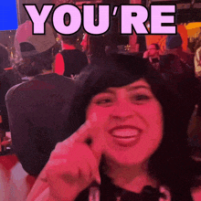 a woman is smiling in front of a sign that reads you 're