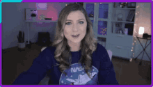 a woman wearing a nasa sweatshirt is sitting in front of a desk