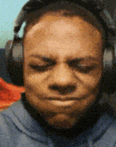 a man wearing headphones is making a sad face