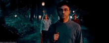 harry potter and his friends are walking through a dark forest at night .
