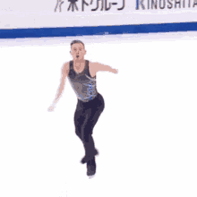 a man in a black tank top and black pants is standing on a ice rink .