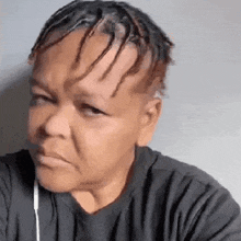 a woman with dreadlocks on her head is wearing a black shirt and headphones .