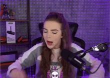 a girl is sitting in front of a shure microphone .
