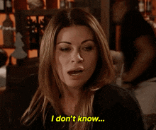 a woman says " i don 't know " while sitting at a table