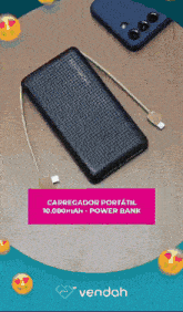 a black power bank is on a wooden table next to a cell phone