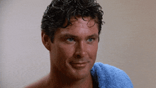 a shirtless man with a blue towel wrapped around his neck