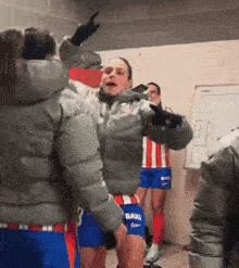 a group of soccer players are standing in a locker room and one of their shorts says barca